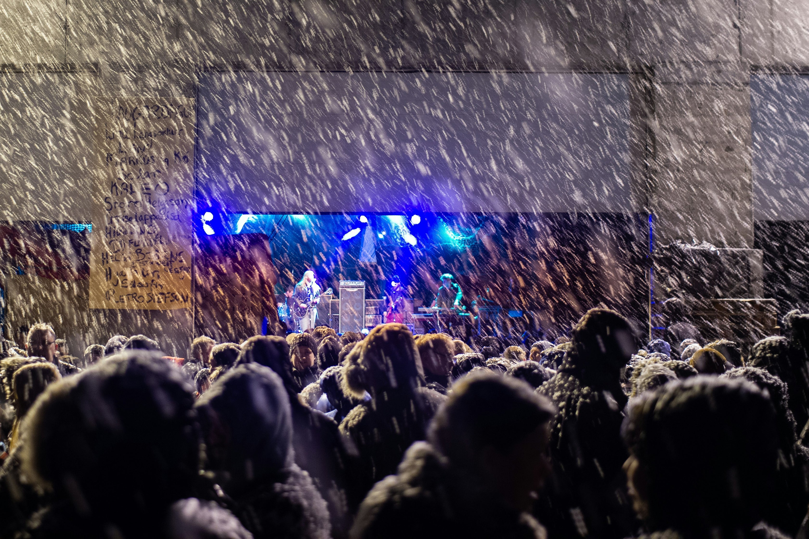 Spectators standing in the rain, watching concerts on the Aldrei festival